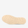 The image shows the bottom of a beige shoe sole with a zigzag tread pattern.