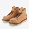 A pair of tan leather lace-up boots with white soles, featuring brown laces, metal eyelets, and detailed stitching.