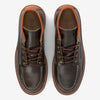 Top view of a pair of dark brown leather boots with tan accents, white stitching, brown laces, and a rugged sole.