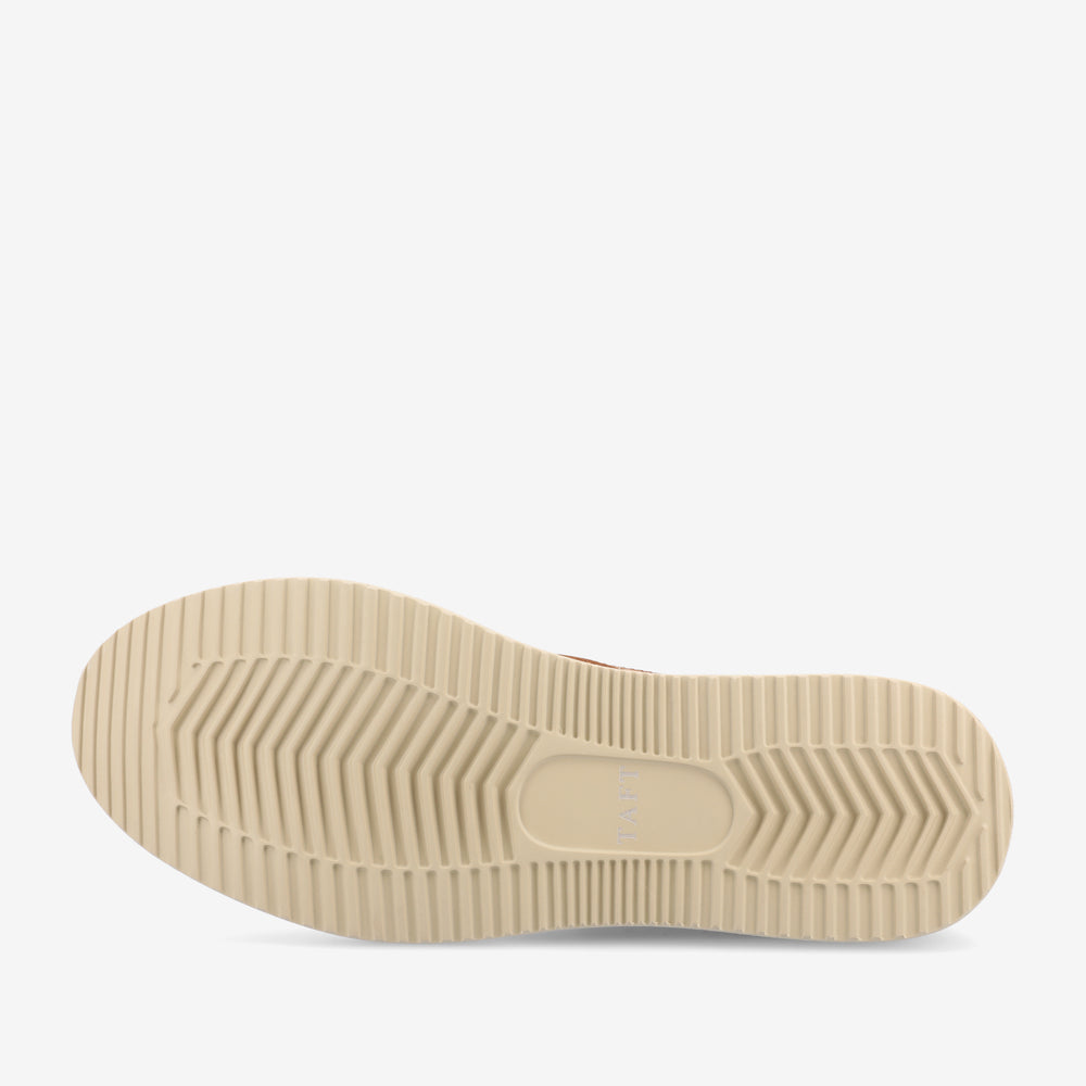 A close-up view of the outsole of a shoe, featuring a beige color with ribbed, textured patterns for traction.