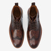 A pair of brown leather lace-up brogue shoes with detailed perforations and a dark gradient finish, viewed from above against a white background.