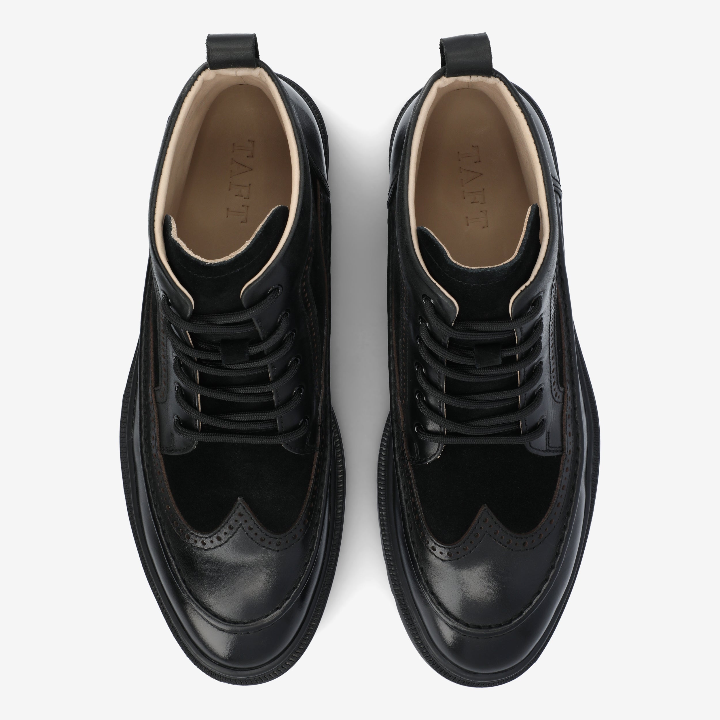 A pair of black leather and suede wingtip shoes with a top-down view, featuring laces and visible brand embossing on the insole.