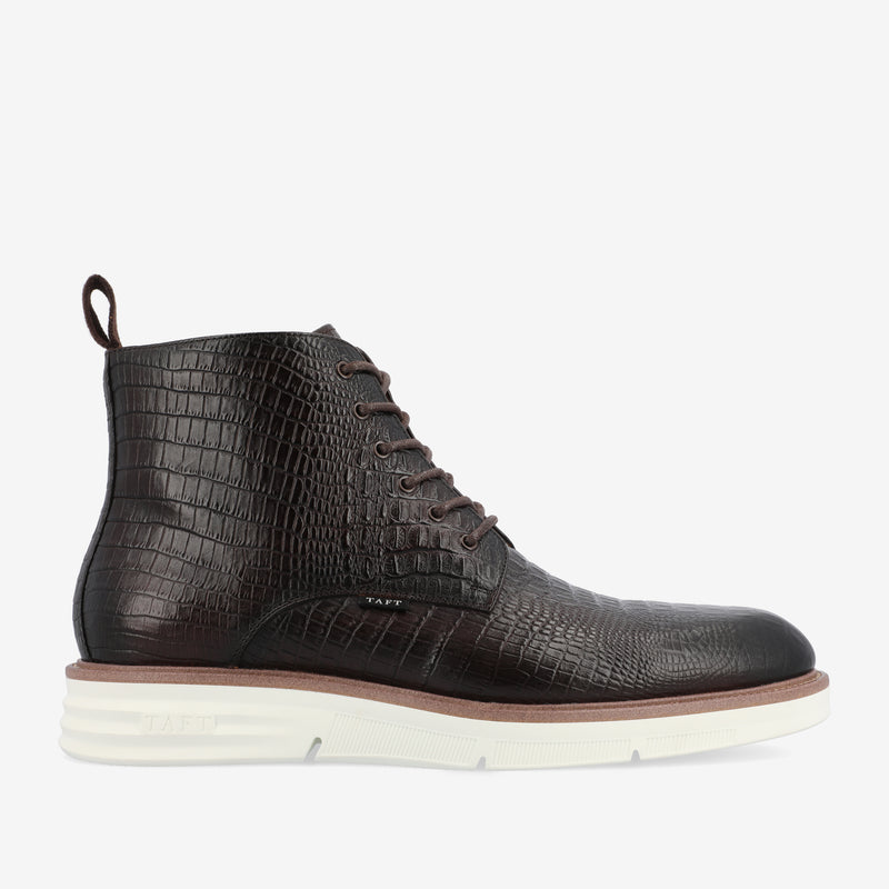 A side view of a dark brown lace-up boot with a textured, crocodile-patterned surface and a thick white sole. The boot has a heel tab and stitching details.