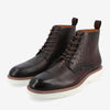 A pair of dark brown, crocodile-patterned leather lace-up boots with white rubber soles and pull tabs on the back.