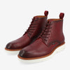 A pair of maroon, high-top leather shoes with a textured pattern, white soles, brown trim, and pull tabs at the back.