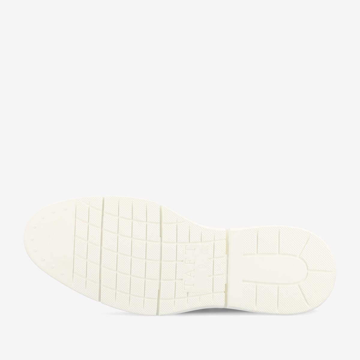 The image shows the bottom view of a white shoe sole with a textured pattern for grip and the word TAFT embossed in the center.