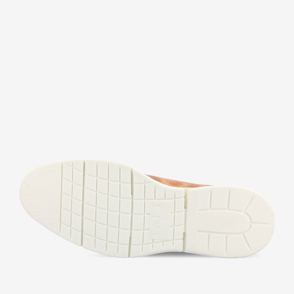 A white rubber sole of a shoe with a grid pattern and TAFT embossed near the heel.