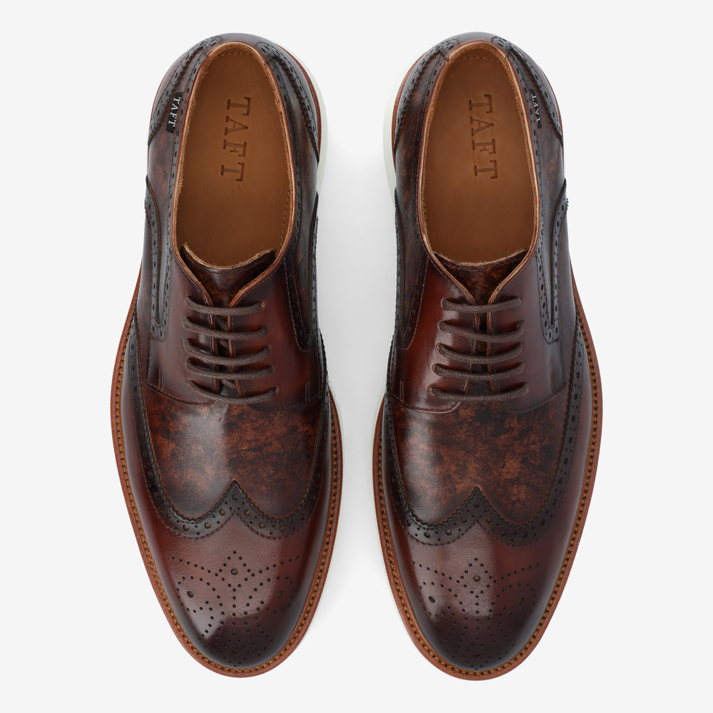 A pair of brown leather cap-toe wingtip dress shoes with decorative perforations, shown from a top-down view.