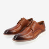 A pair of brown leather dress shoes with white rubber soles and decorative perforations.