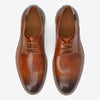 Brown leather dress shoes with decorative perforations and laces, viewed from above against a white background.