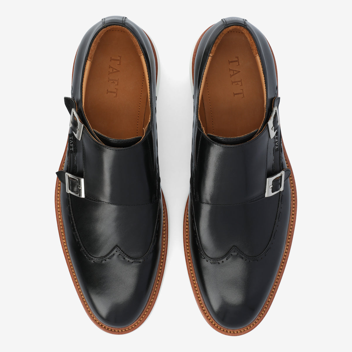 A pair of black leather dress shoes with silver buckles and brown soles, viewed from above. The brand name TAFT is visible inside the shoes.