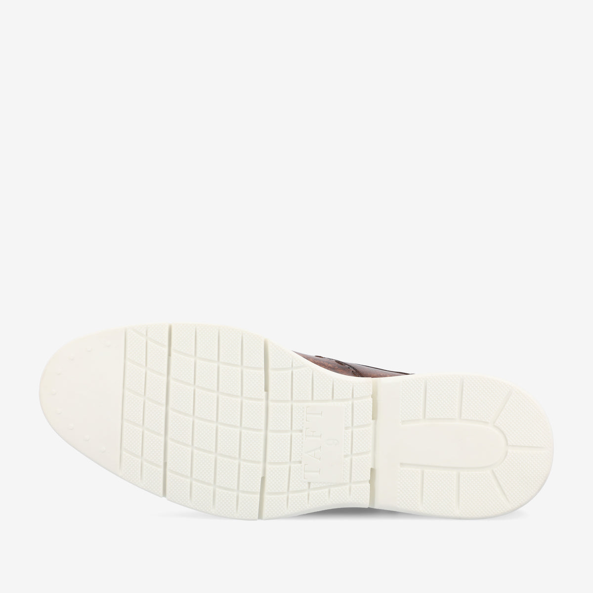 The image shows the sole of a shoe with a white, textured rubber surface and a grid pattern for traction. A label with the word TAFT is visible at the center of the sole.