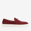 Red suede slip-on shoe with a white rubber sole, featuring a small bow detail on the top.