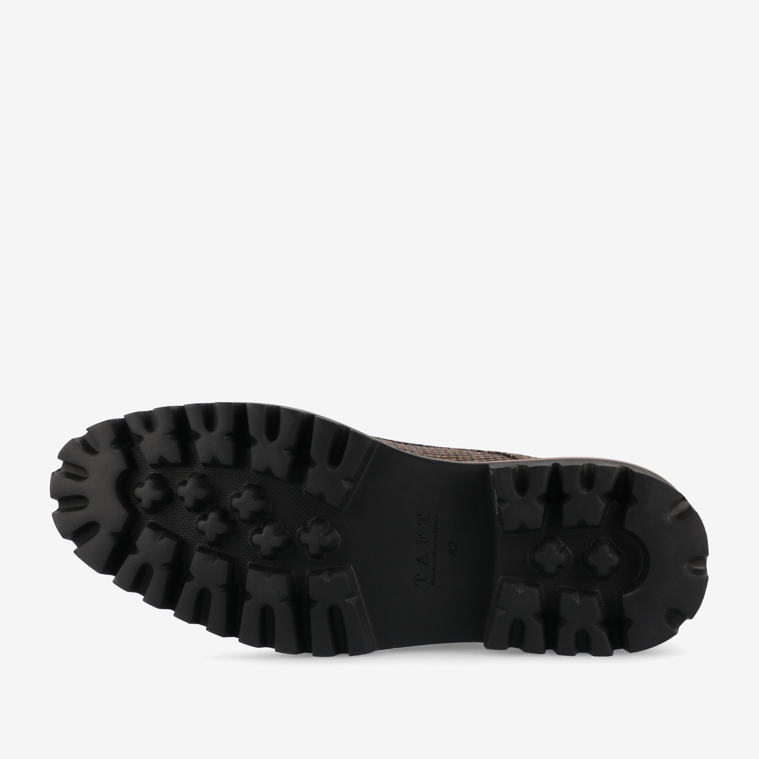 The image shows the bottom view of a black, rugged sole of a shoe with deep treads for better traction.