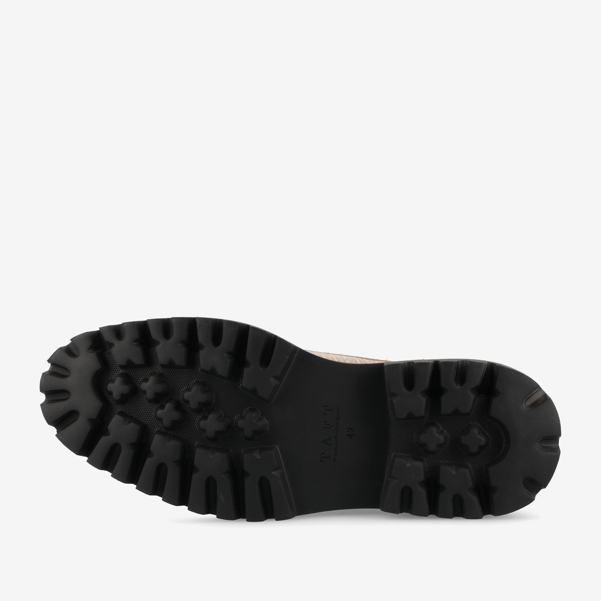 Bottom view of a black rubber sole of a shoe with deep treads on a plain white background.