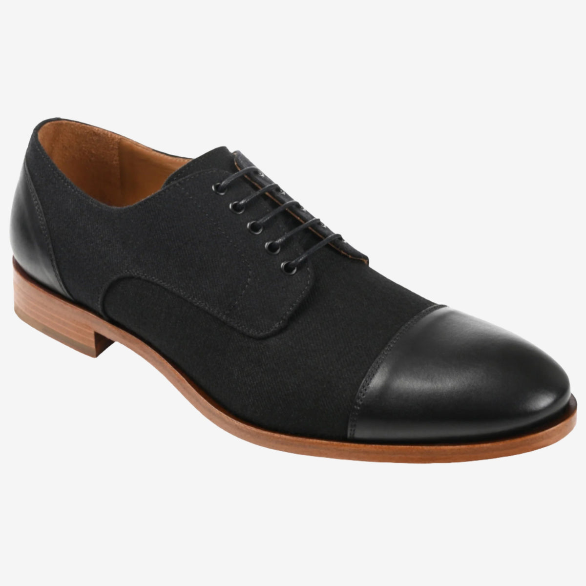 Black leather and fabric men's dress shoe with tan sole and black laces on a white background.