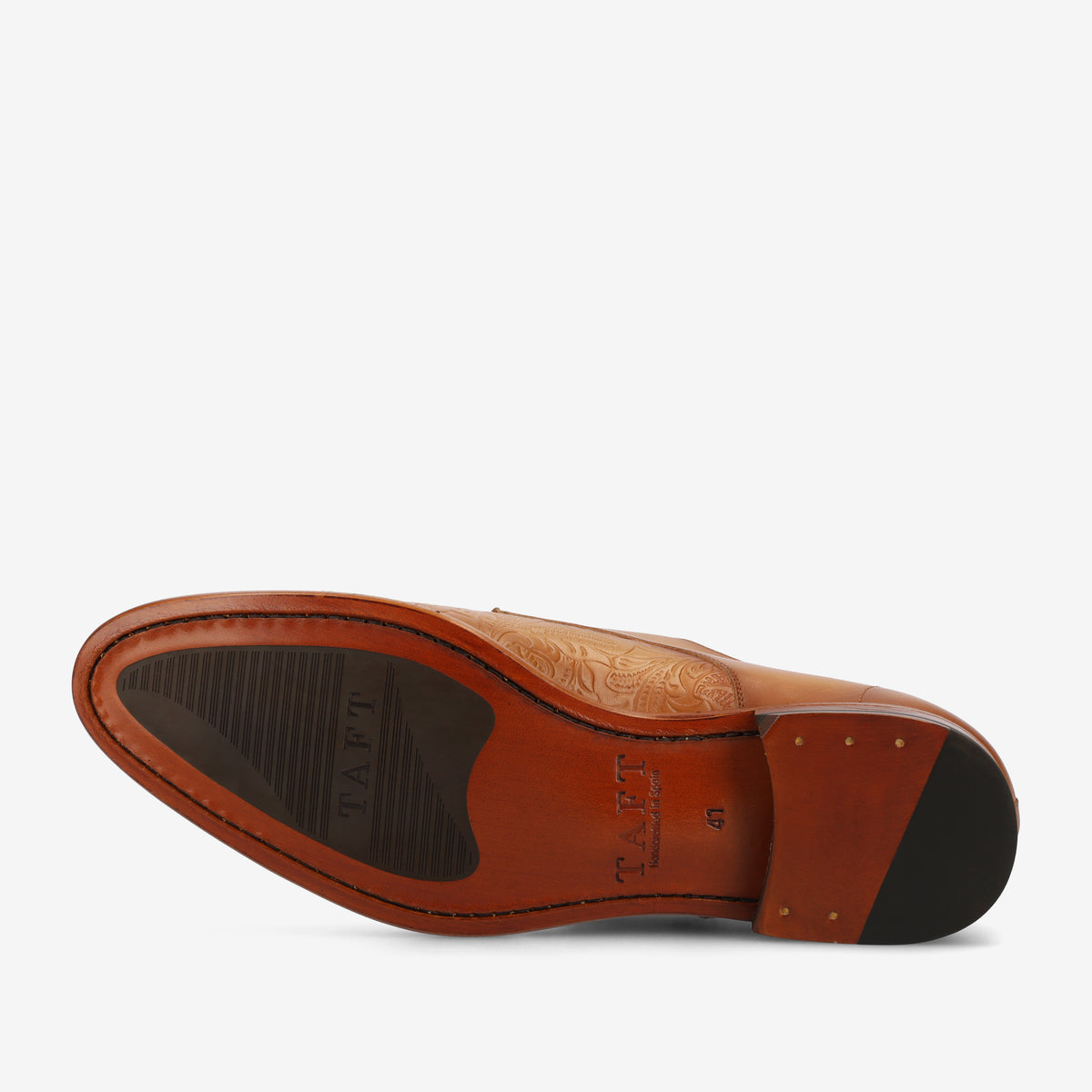 Bottom view of a tan leather dress shoe showing a patterned sole, rubber grip, and TAFT branding.