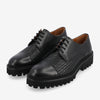 A pair of black men's dress shoes featuring woven leather on the sides, smooth leather toe caps, and thick rubber soles with lug tread patterns.