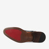 Sole of a black dress shoe showing a mix of brown leather and red rubber texture with the brand name TAFT imprinted on the bottom.