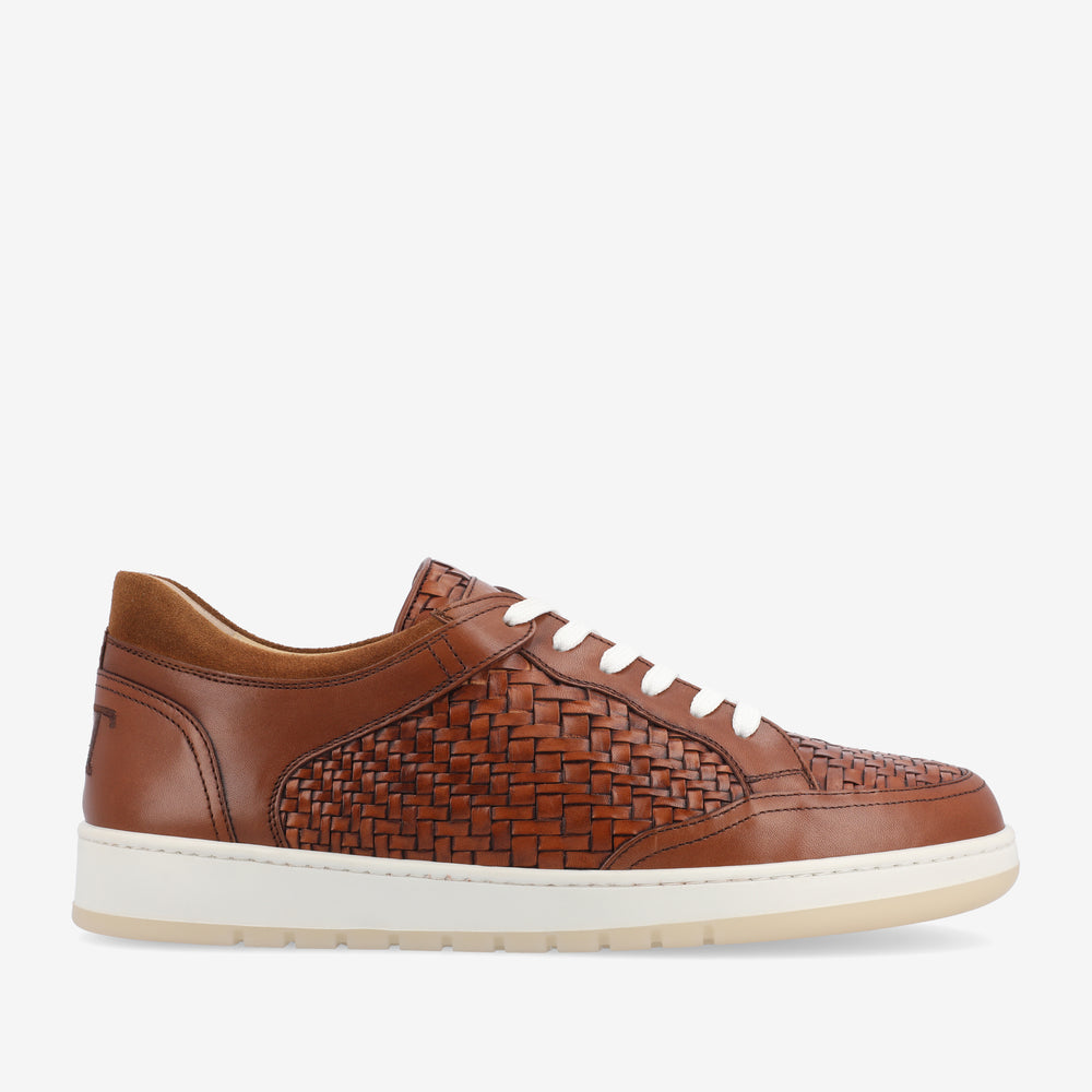 Brown woven leather sneaker with white laces and a white rubber sole, side view.