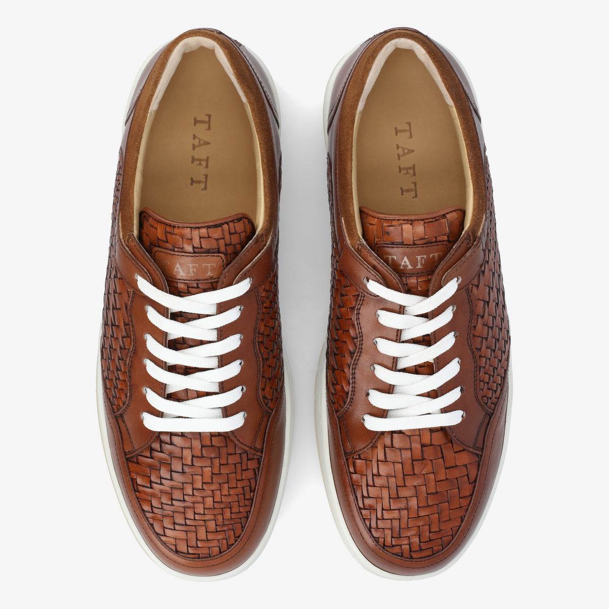 Pair of brown woven leather sneakers with white laces, viewed from above, featuring a TAFT brand logo on the insoles.