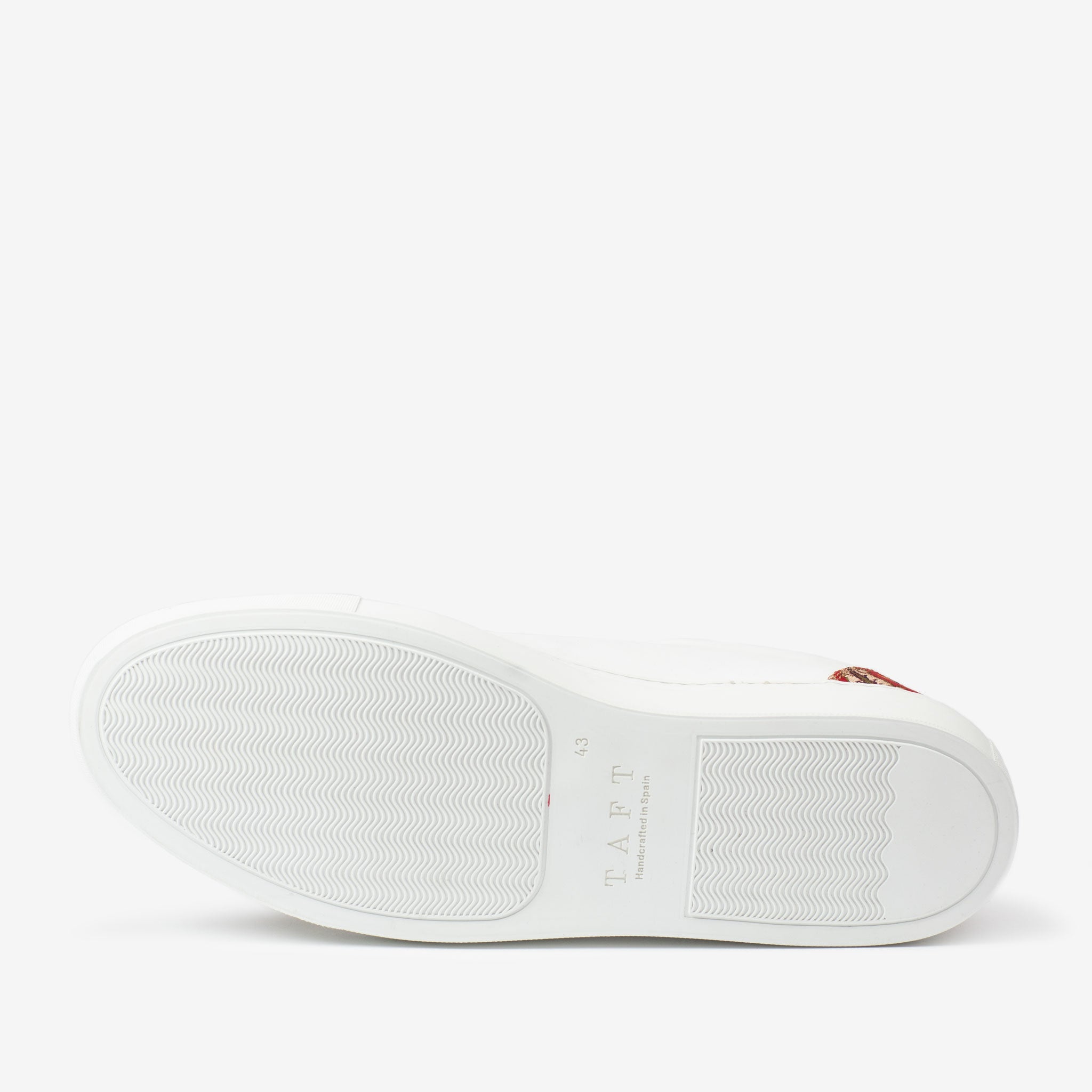 The image shows the bottom view of a white sneaker with a wavy tread pattern and the brand name TAFT printed near the heel.