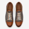 Pair of brown leather and houndstooth sneakers with white laces and white soles, viewed from above.