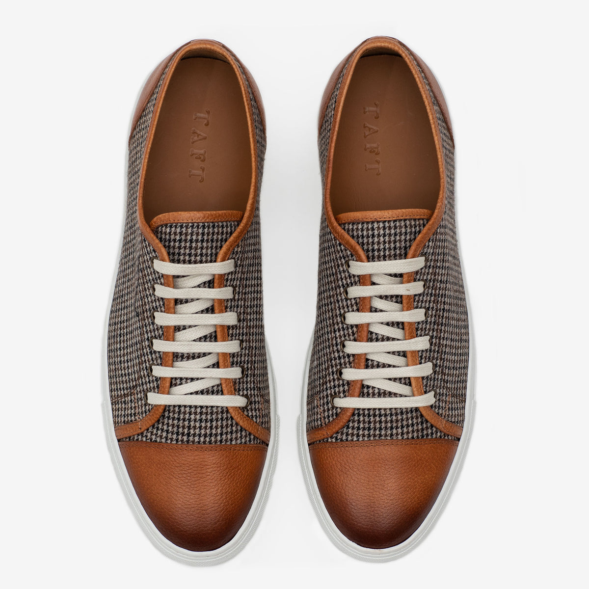 Pair of brown leather and houndstooth sneakers with white laces and white soles, viewed from above.