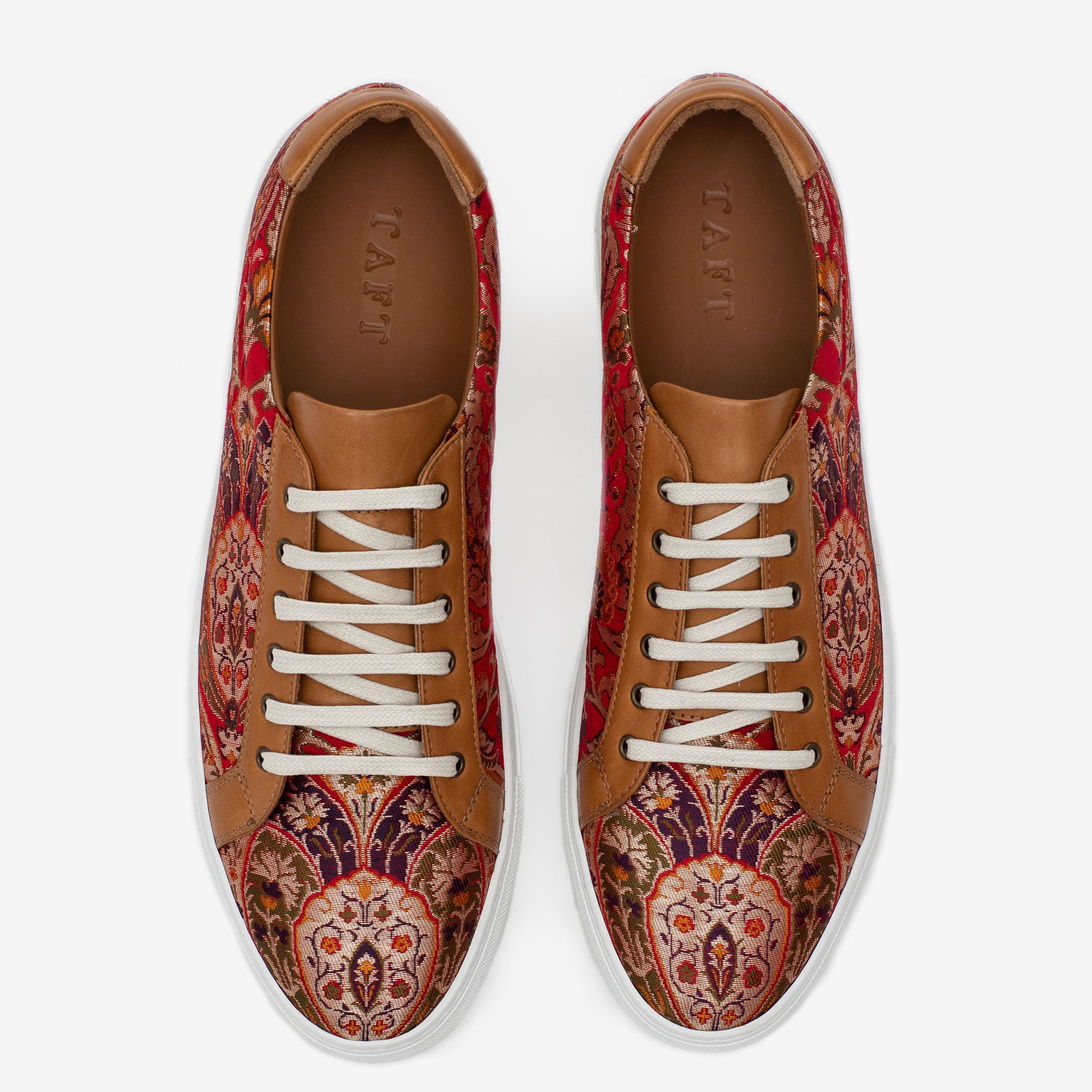 Top view of a pair of patterned sneakers with red, brown, and white colors, featuring white laces and TAFT inscribed on the brown insole.