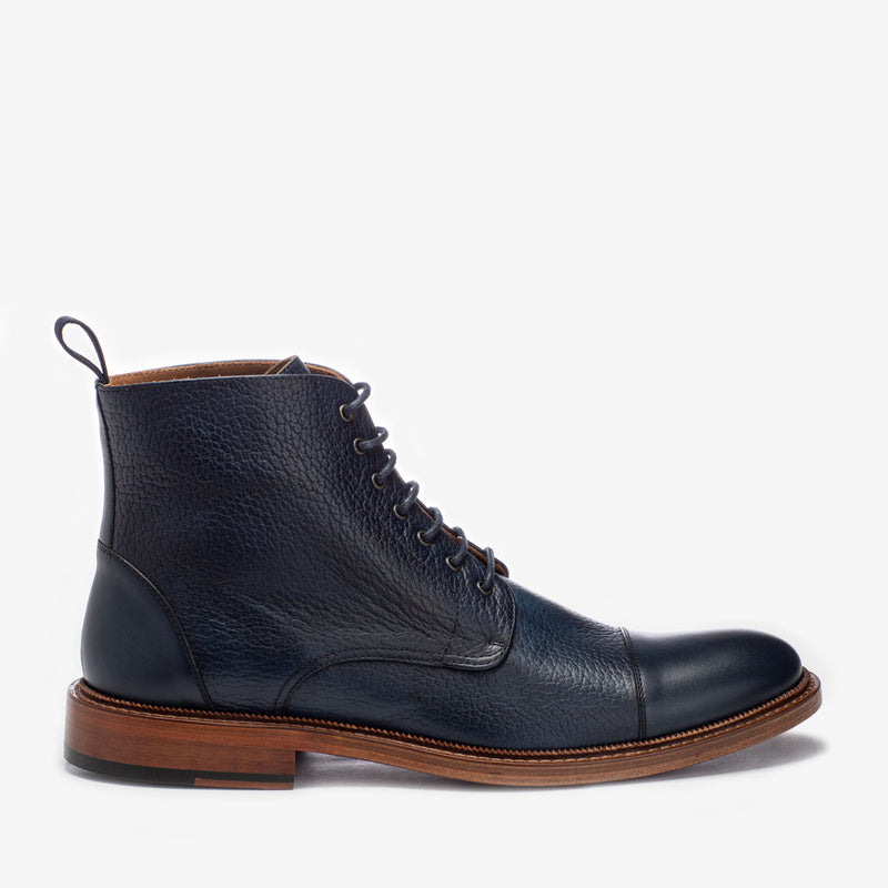 A black leather lace-up boot with a brown sole, a pull tab at the heel, and stitching details.