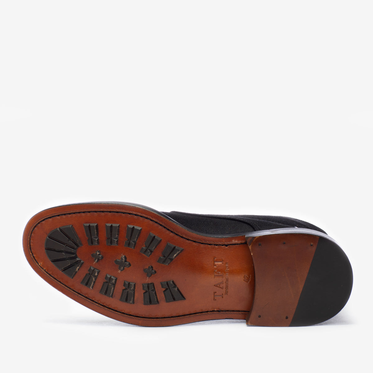 Black shoe with a brown sole, featuring TAFT branding and black rubber traction patterns on the bottom.