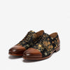 A pair of men's dress shoes with black fabric featuring gold floral patterns and brown leather cap toes and soles, displayed against a white background.