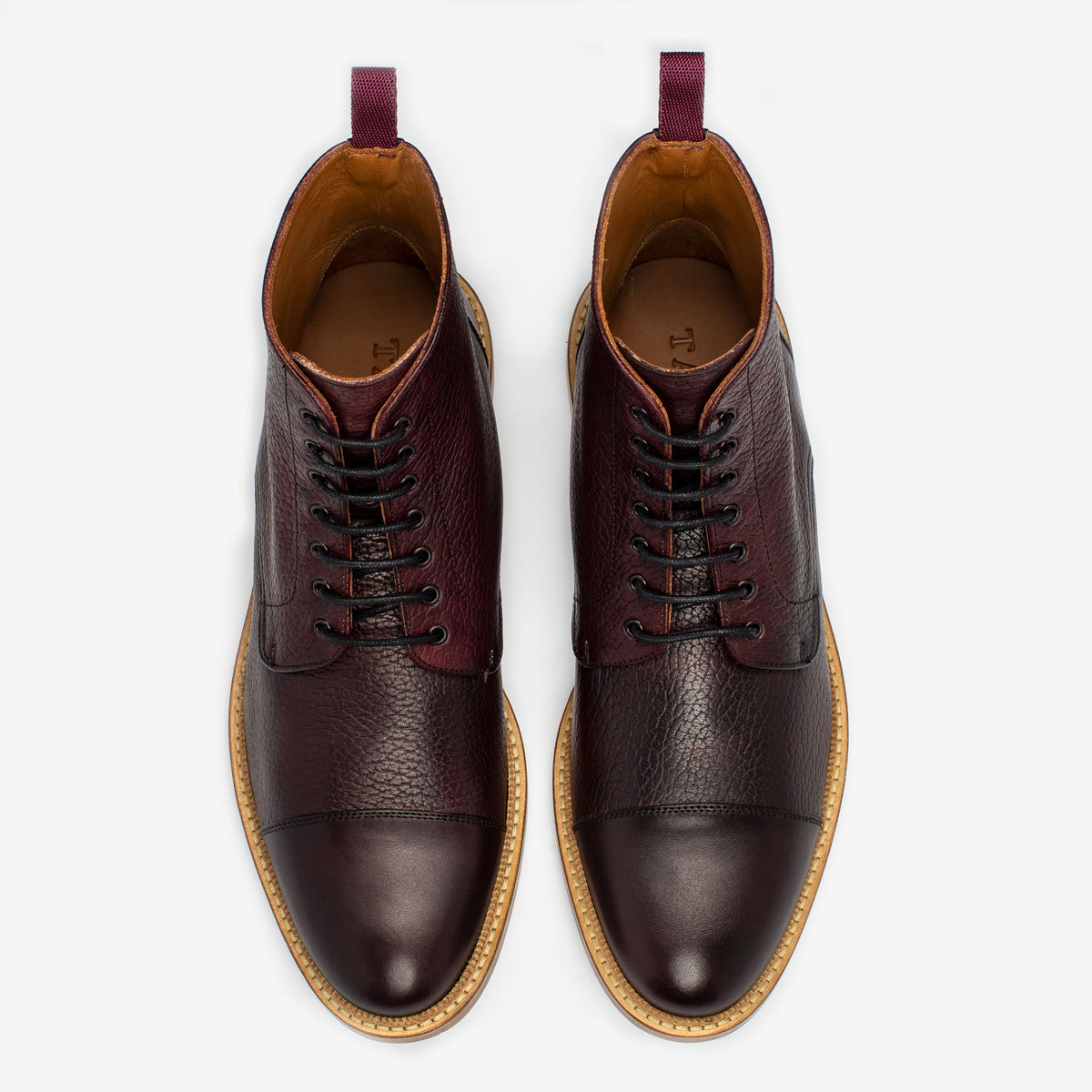 Top view of a pair of dark brown leather lace-up boots with a light brown sole, set against a white background.