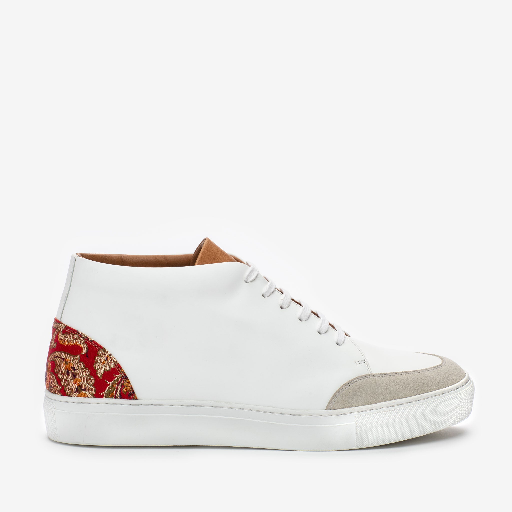 A white high-top sneaker with a beige toe cap and a red patterned fabric accent at the rear.