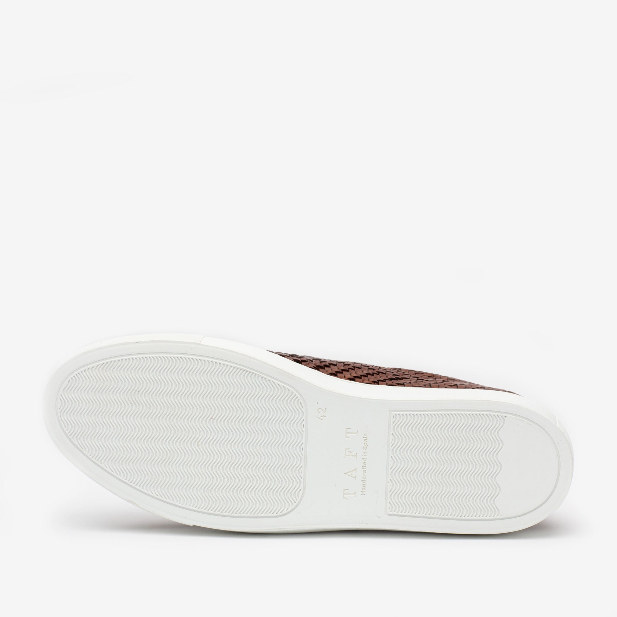 The image shows the sole of a brown woven-texture shoe with a white rubber outsole, featuring the brand TAFT embossed on the heel.