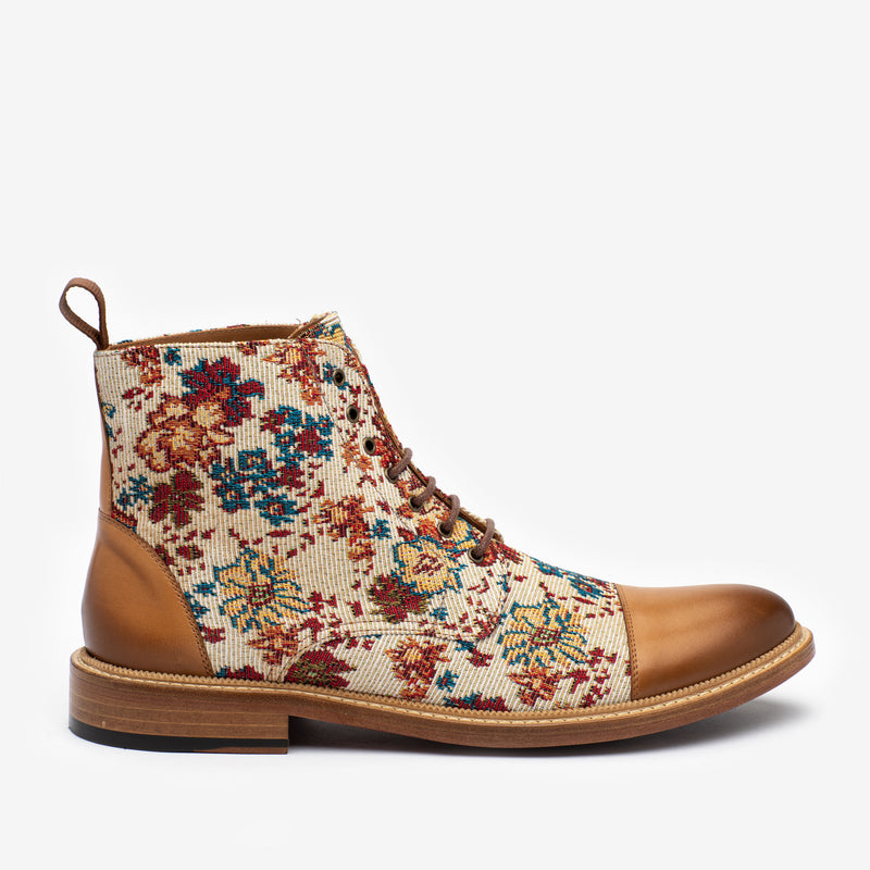 A mid-ankle boot with a floral-patterned fabric upper and tan leather toe and heel, featuring lace-up closure and a low wooden sole.