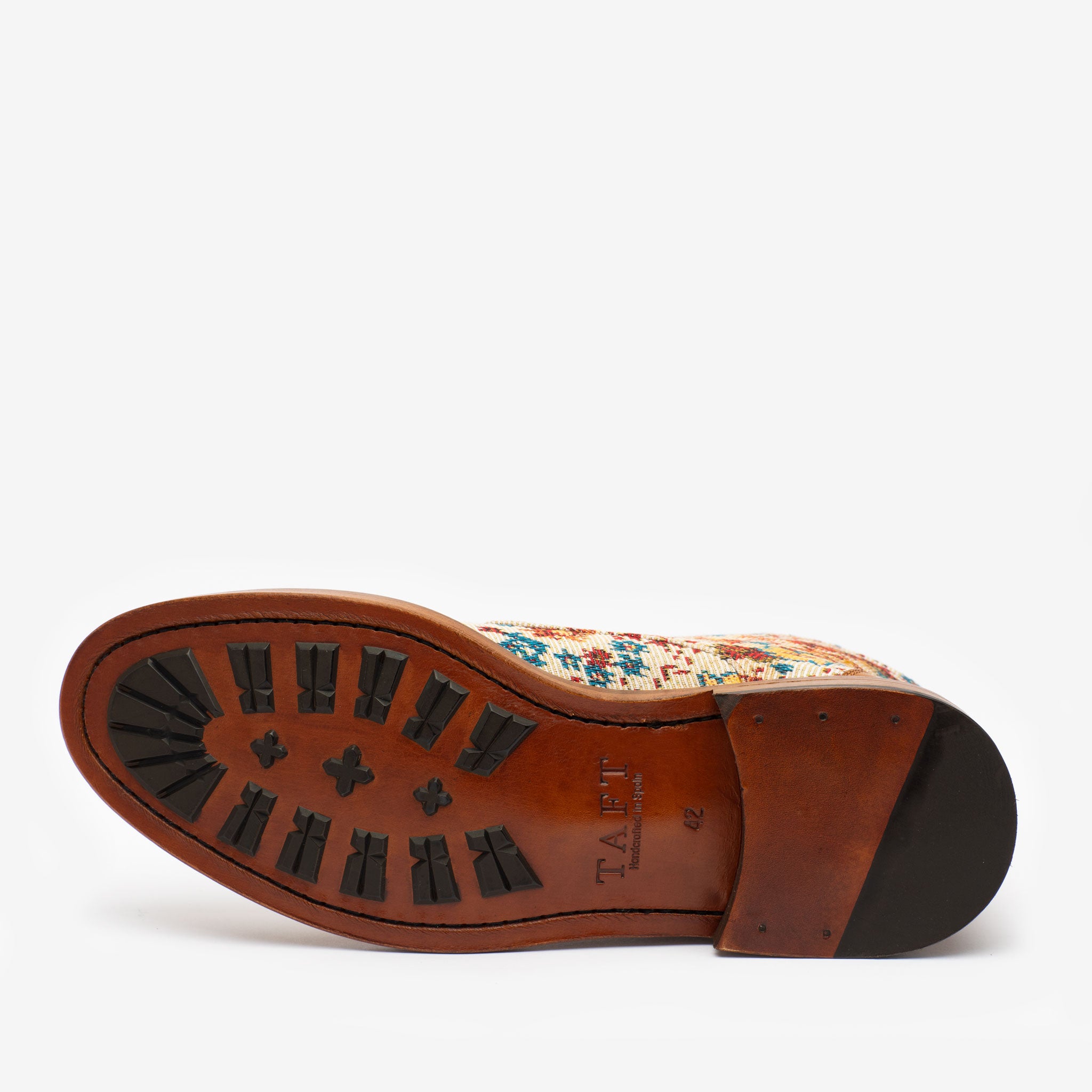 The image shows the sole of a TAFT dress shoe with a leather base and black tread patterns. The upper part of the shoe has a colorful design.