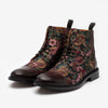 A pair of lace-up boots with a floral and bird pattern on the upper part and dark brown leather on the toe and heel.