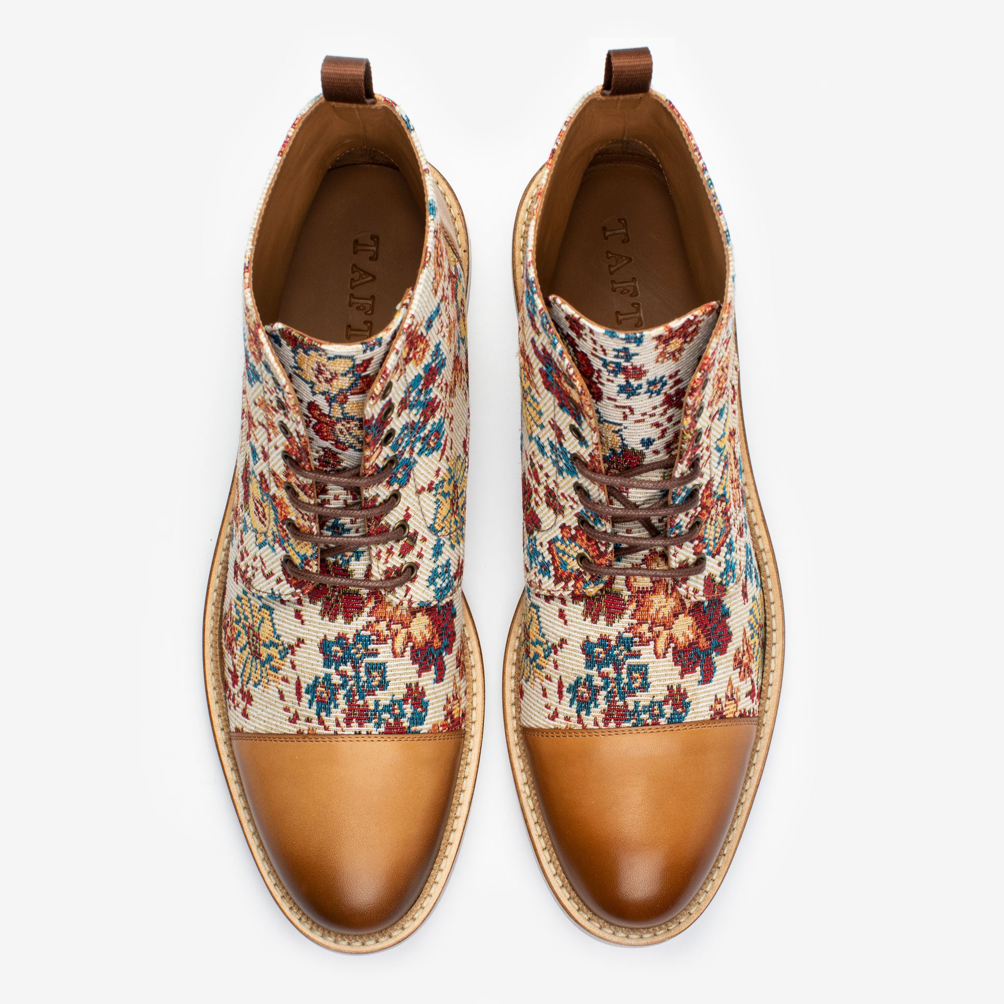 Top-down view of a pair of lace-up shoes with brown leather toe caps and heels, and floral-patterned fabric uppers.