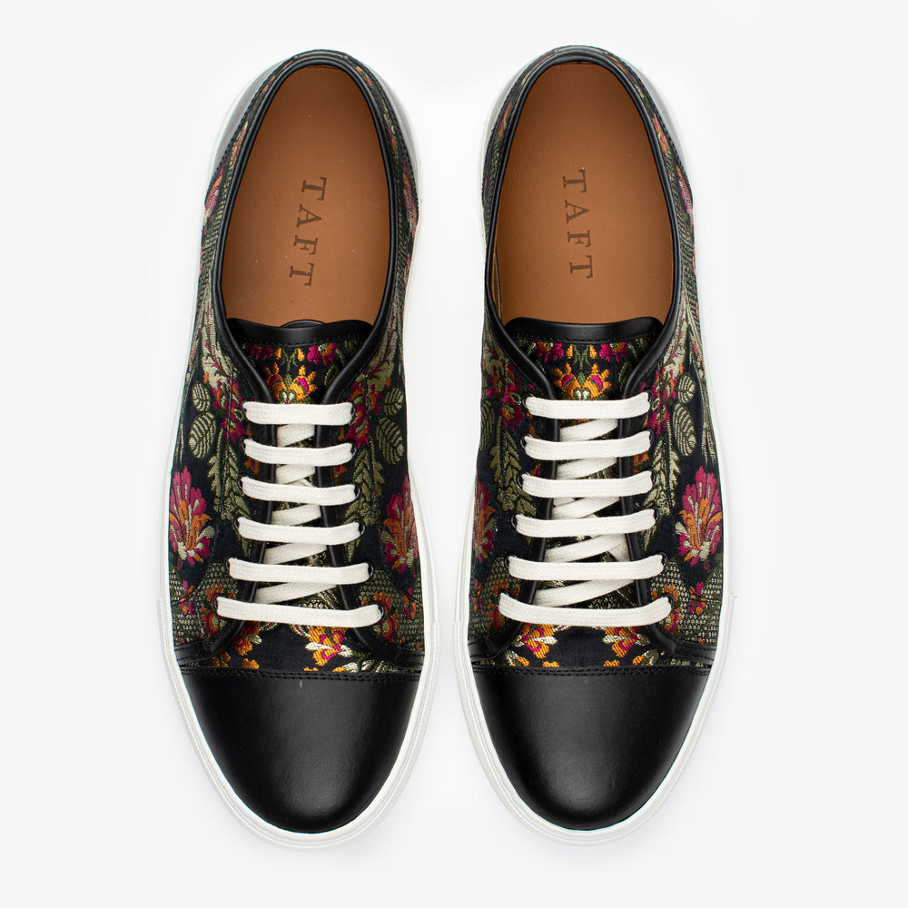 A pair of floral-patterned sneakers with black toe caps and white laces, displayed side by side. The insoles are branded TAFT.