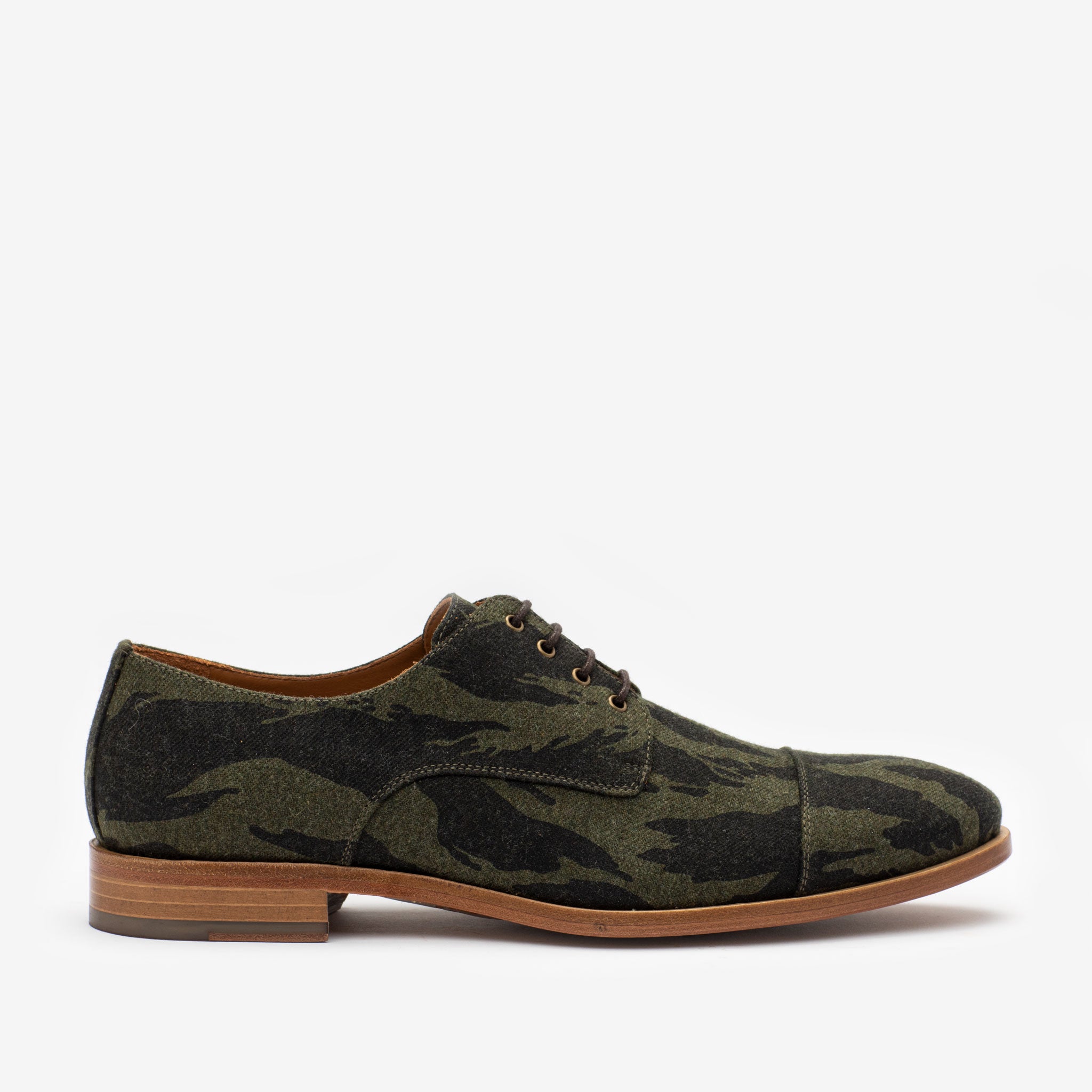 A single men's dress shoe with a green camouflage pattern, brown laces, and a wooden sole.