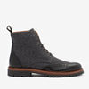 A black and gray lace-up boot featuring brogue detailing, a leather toe cap, fabric upper, and a sturdy sole with a pull tab at the back.