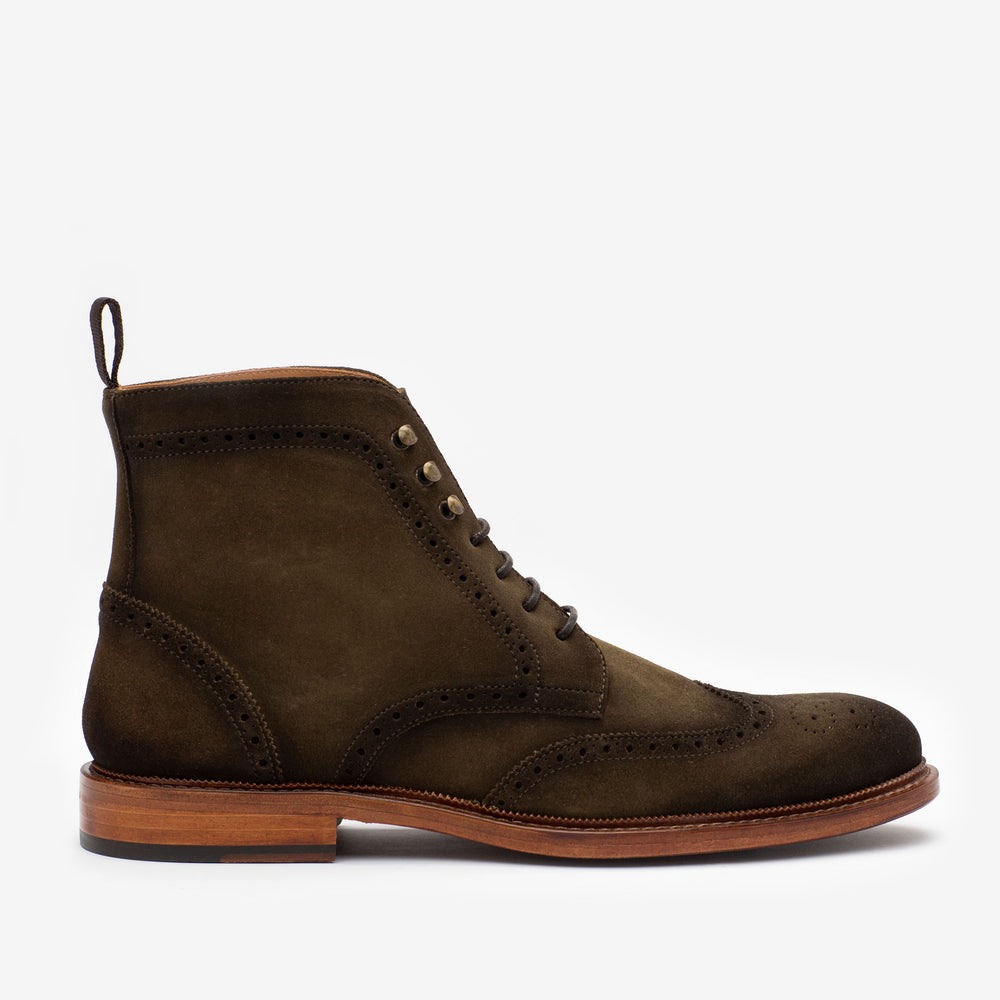 Olive suede brogue boot with decorative perforations, lace-up style, and wooden sole, displayed against a plain white background.