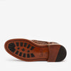 The image shows the sole of a brown woven leather shoe with a sturdy rubber tread.