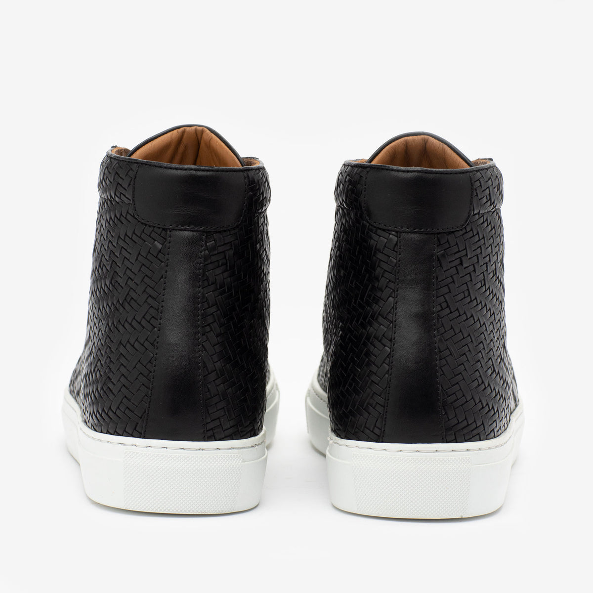 Back view of black high-top sneakers with woven textured design and white rubber soles.