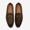 A pair of brown suede loafers with metallic horsebit detailing, viewed from above. The word TAFT is inscribed inside each shoe.