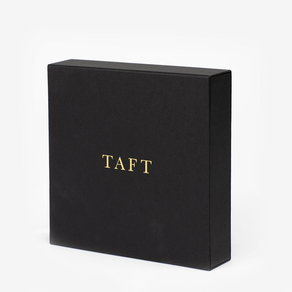 A black square box with TAFT written in gold capital letters on the front.