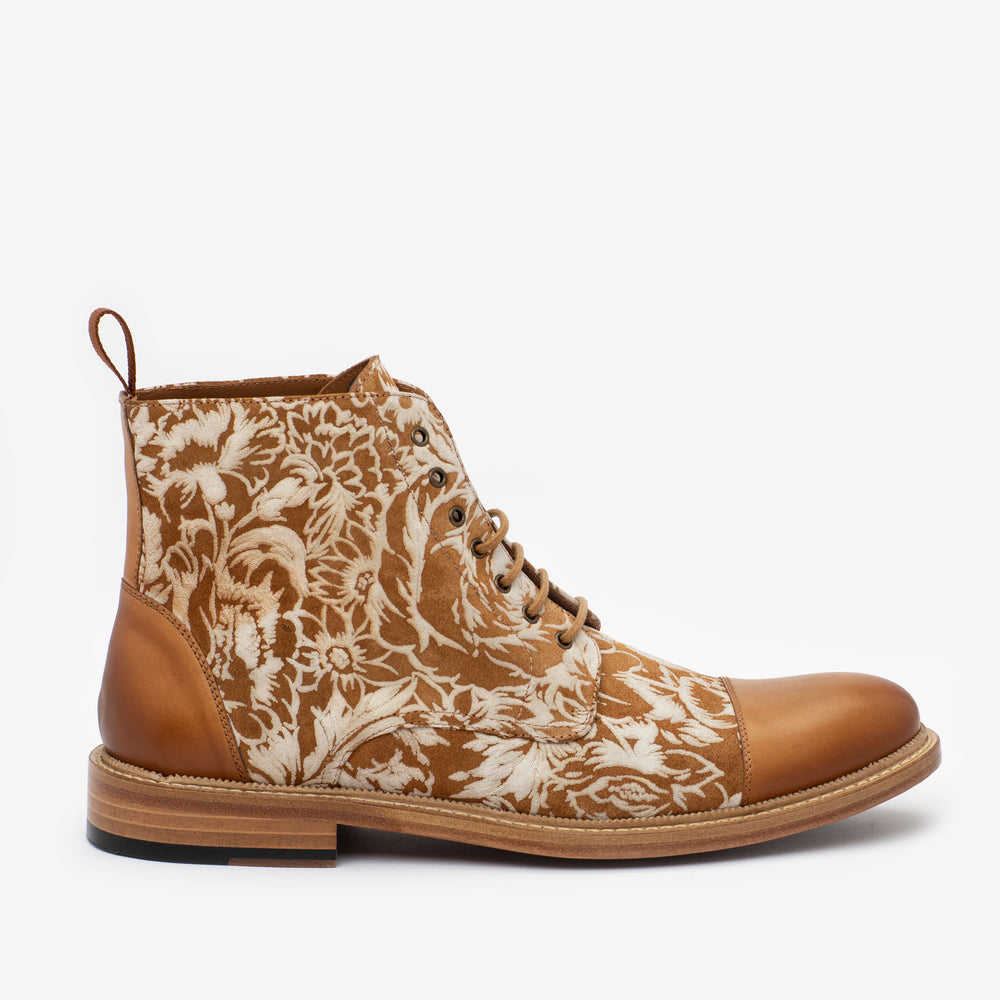 A brown leather and floral-patterned fabric lace-up boot with a rubber sole, photographed from the side.