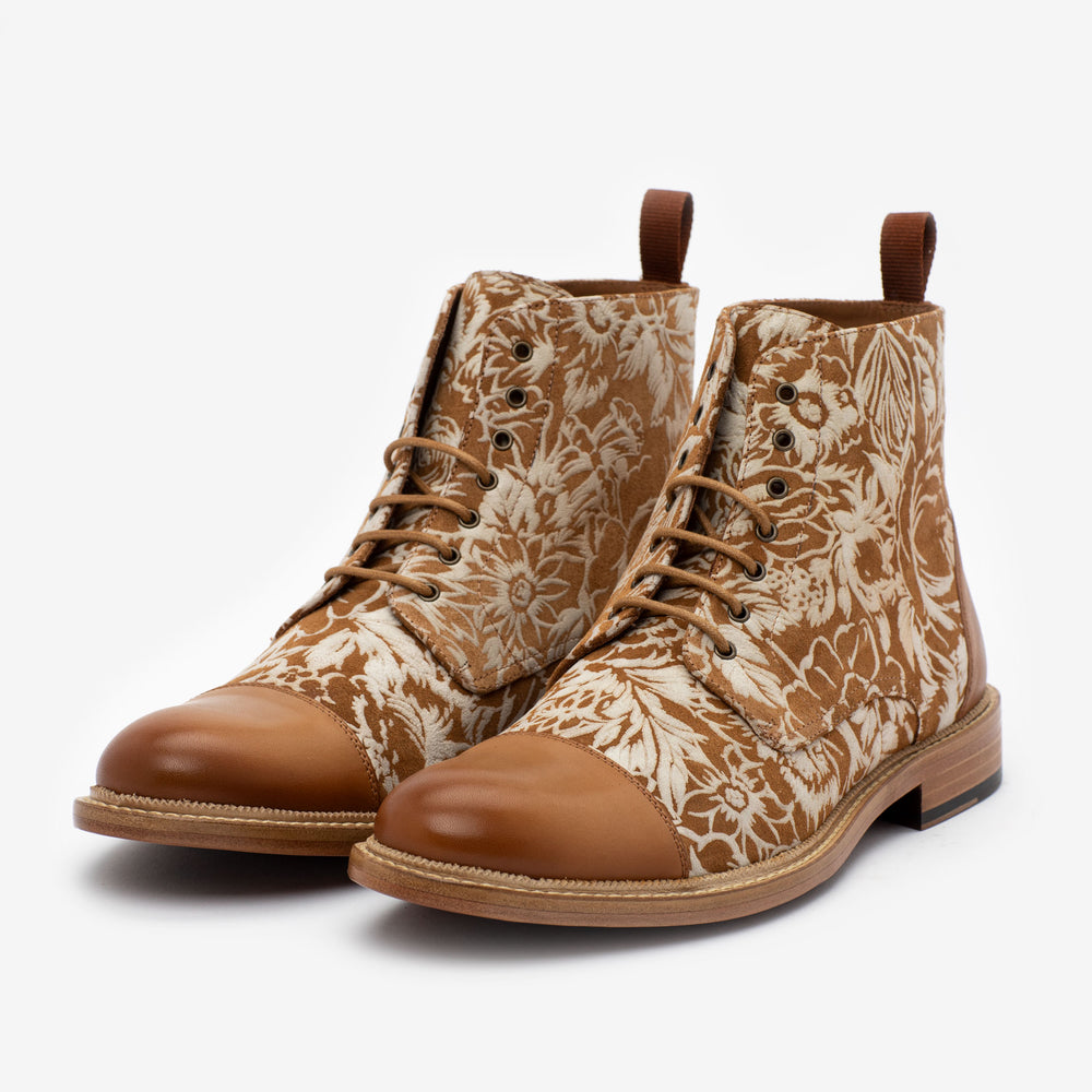 A pair of brown lace-up boots with a floral pattern on the sides and smooth leather on the toes and heels.