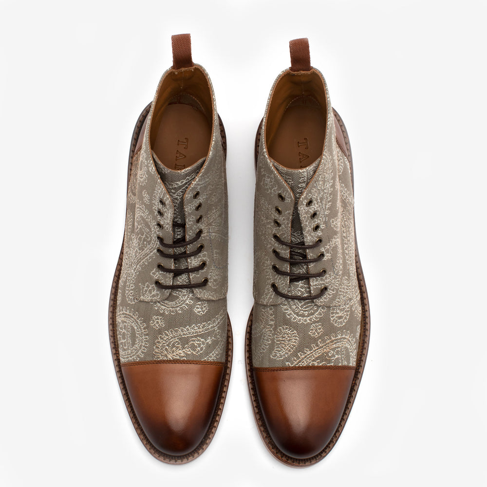 Top view of a pair of men's ankle-length dress shoes with brown leather toe caps and heels, and a patterned beige fabric body.